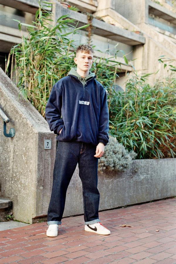 Navy blue fleece sweatshirt featuring 'Dream But Do Not Sleep' embroidered design on the front, showcasing cozy fleece material and relaxed fit.