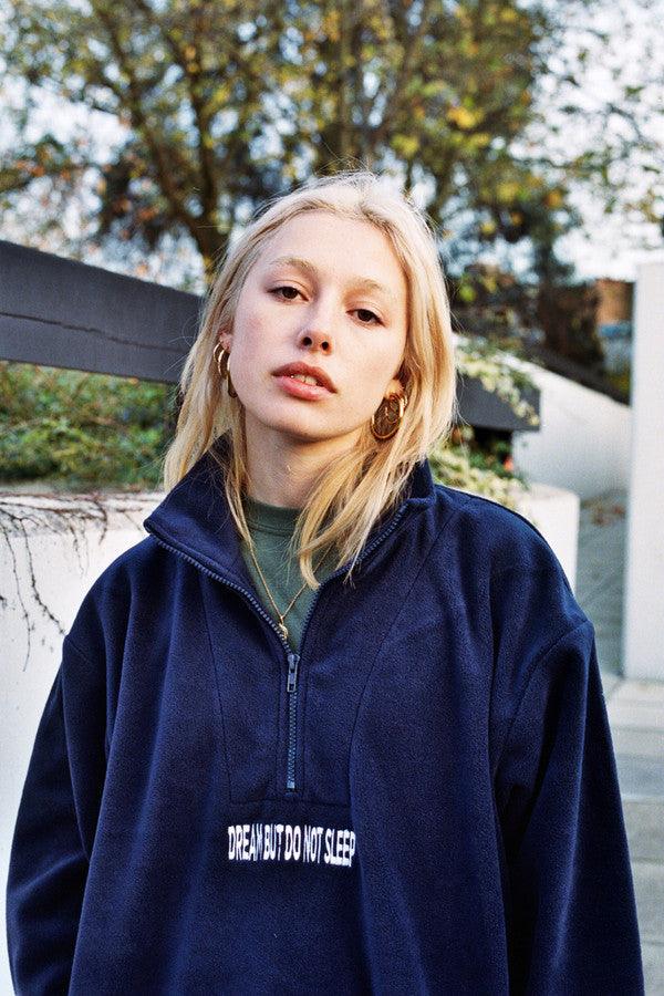 Navy blue fleece sweatshirt featuring 'Dream But Do Not Sleep' embroidered design on the front, showcasing cozy fleece material and relaxed fit.