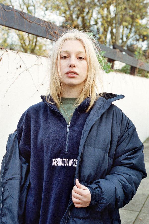 Navy blue fleece sweatshirt featuring 'Dream But Do Not Sleep' embroidered design on the front, showcasing cozy fleece material and relaxed fit.