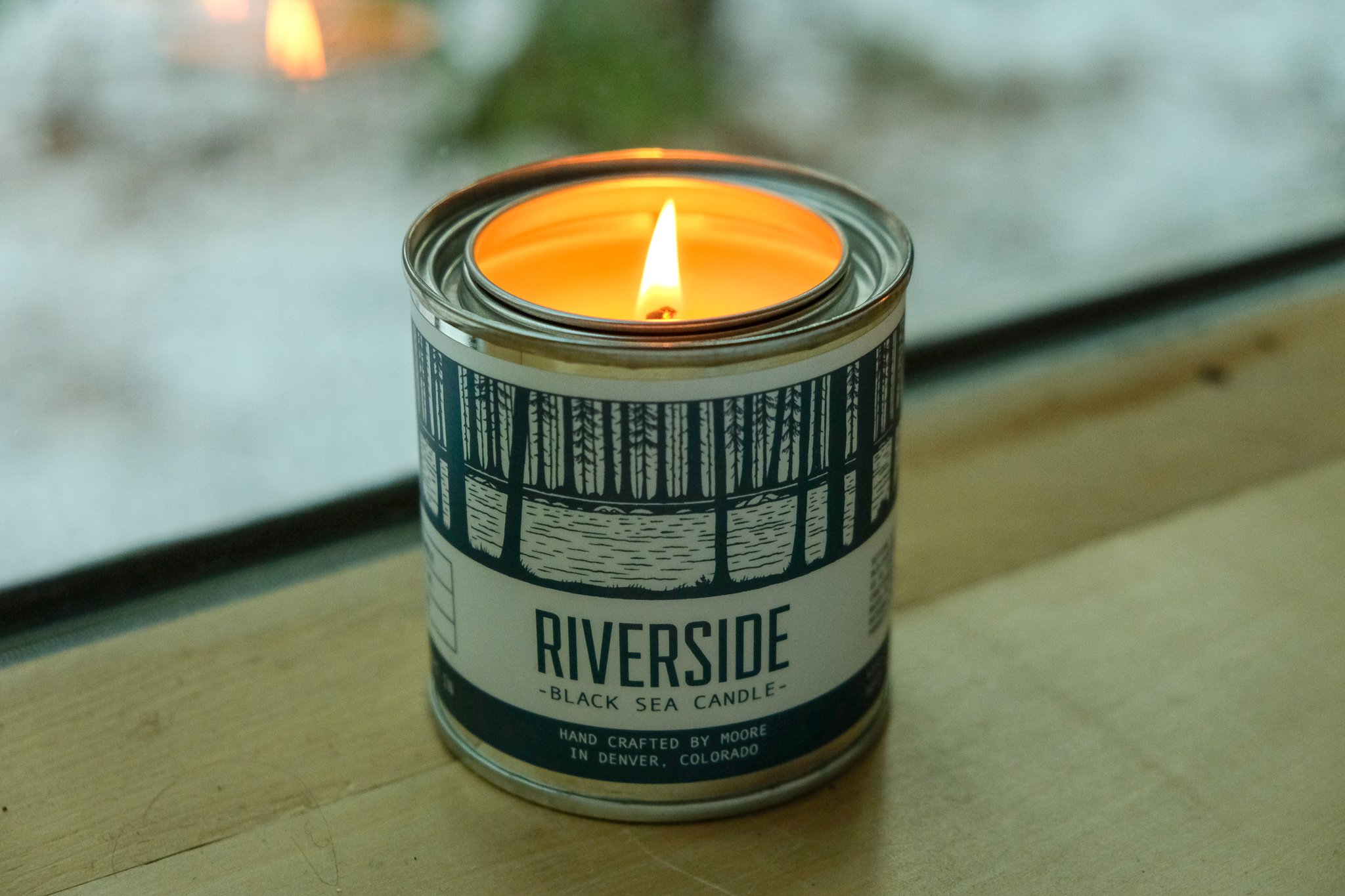 Riverside Candle in a serene setting, showcasing its natural soy wax and beautiful label design inspired by nature.