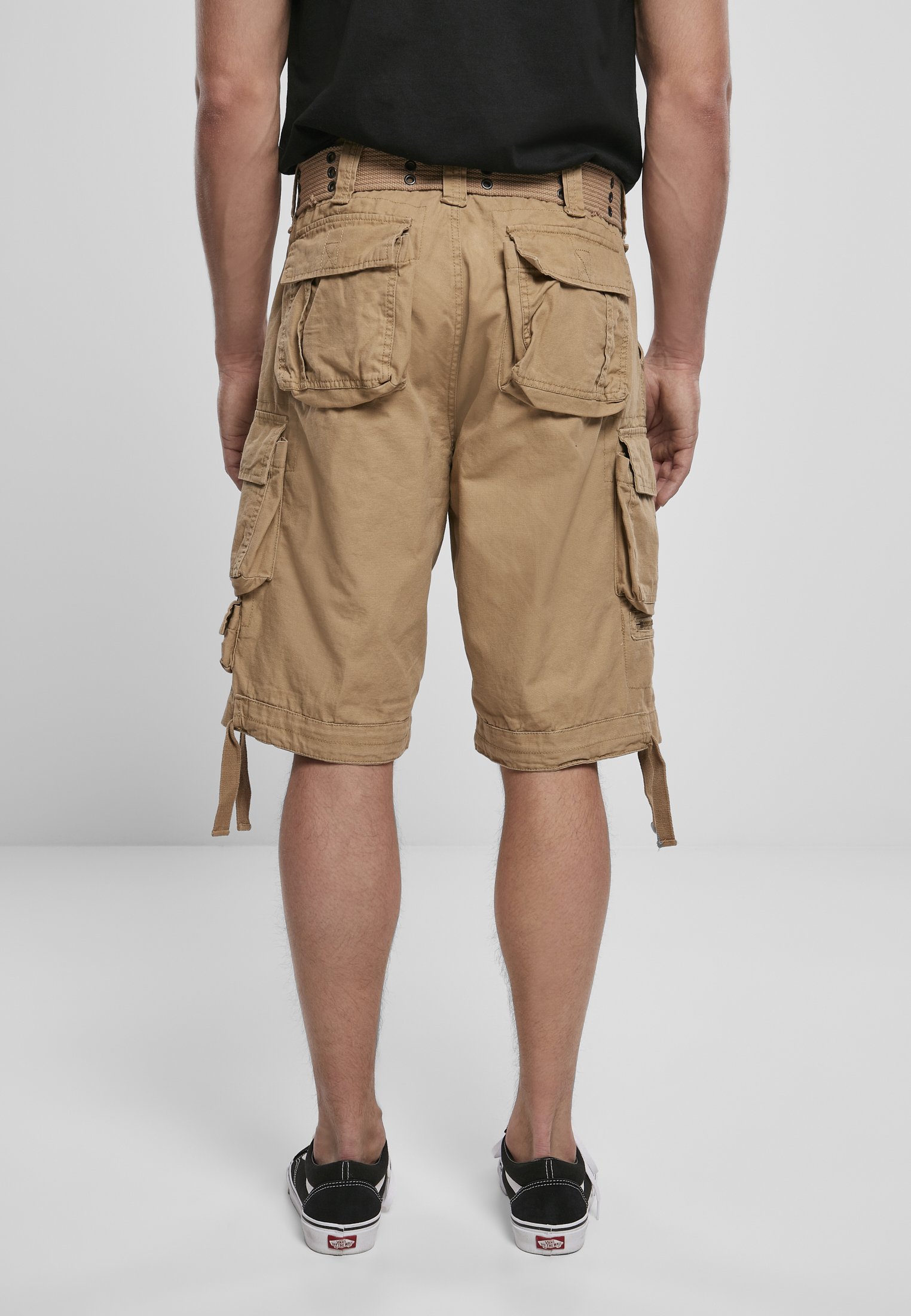 Savage Vintage Cargo Shorts in a rugged outdoor setting, showcasing large side pockets and decorative belt with eyelets.