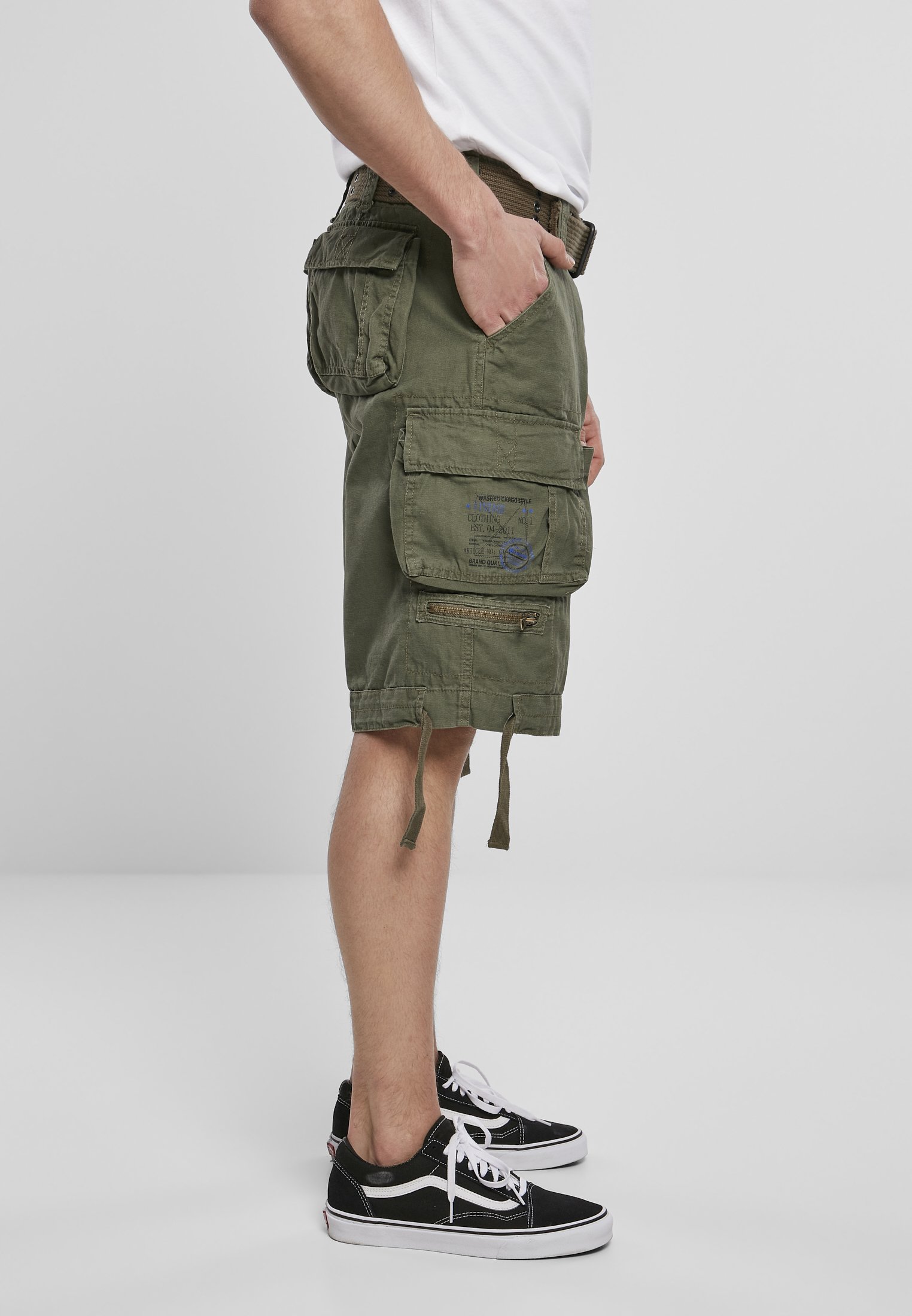 Savage Vintage Cargo Shorts in a rugged outdoor setting, showcasing large side pockets and decorative belt with eyelets.