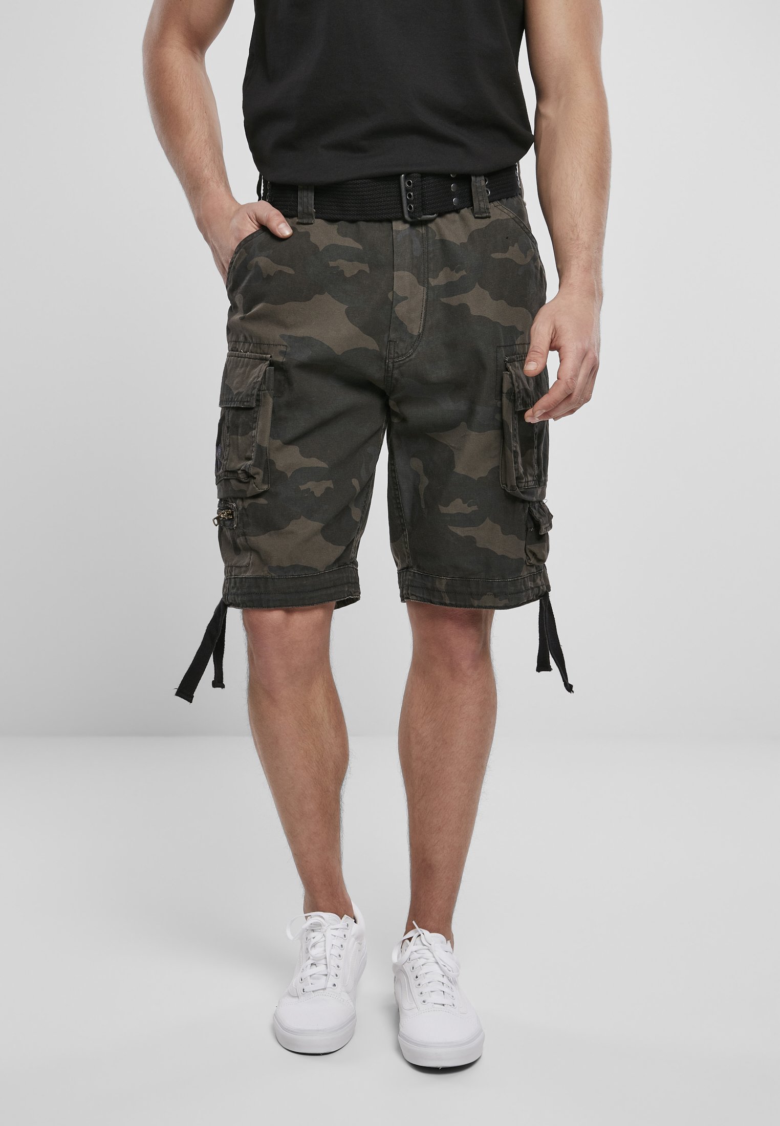 Savage Vintage Cargo Shorts in a rugged outdoor setting, showcasing large side pockets and decorative belt with eyelets.