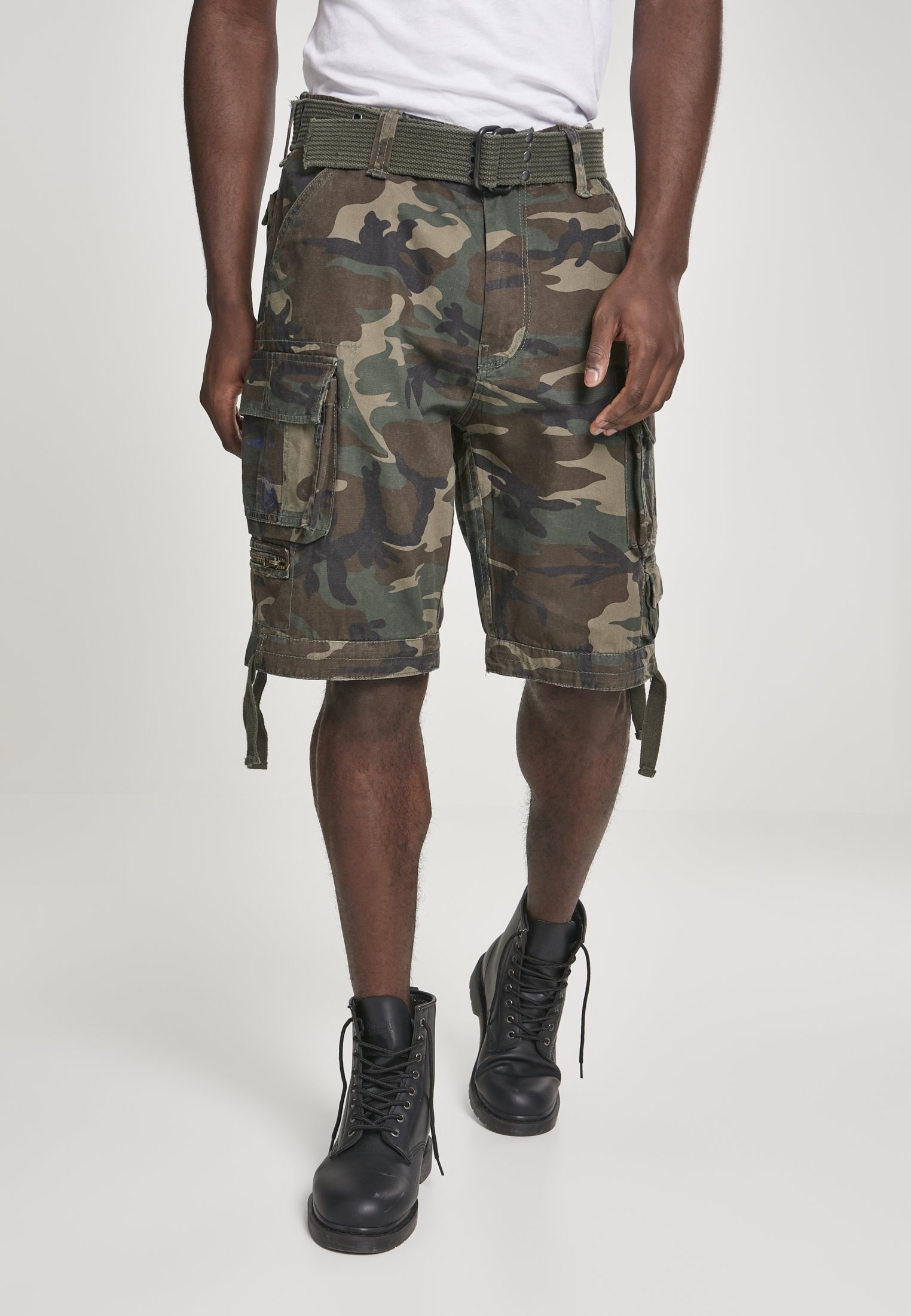 Savage Vintage Cargo Shorts in a rugged outdoor setting, showcasing large side pockets and decorative belt with eyelets.