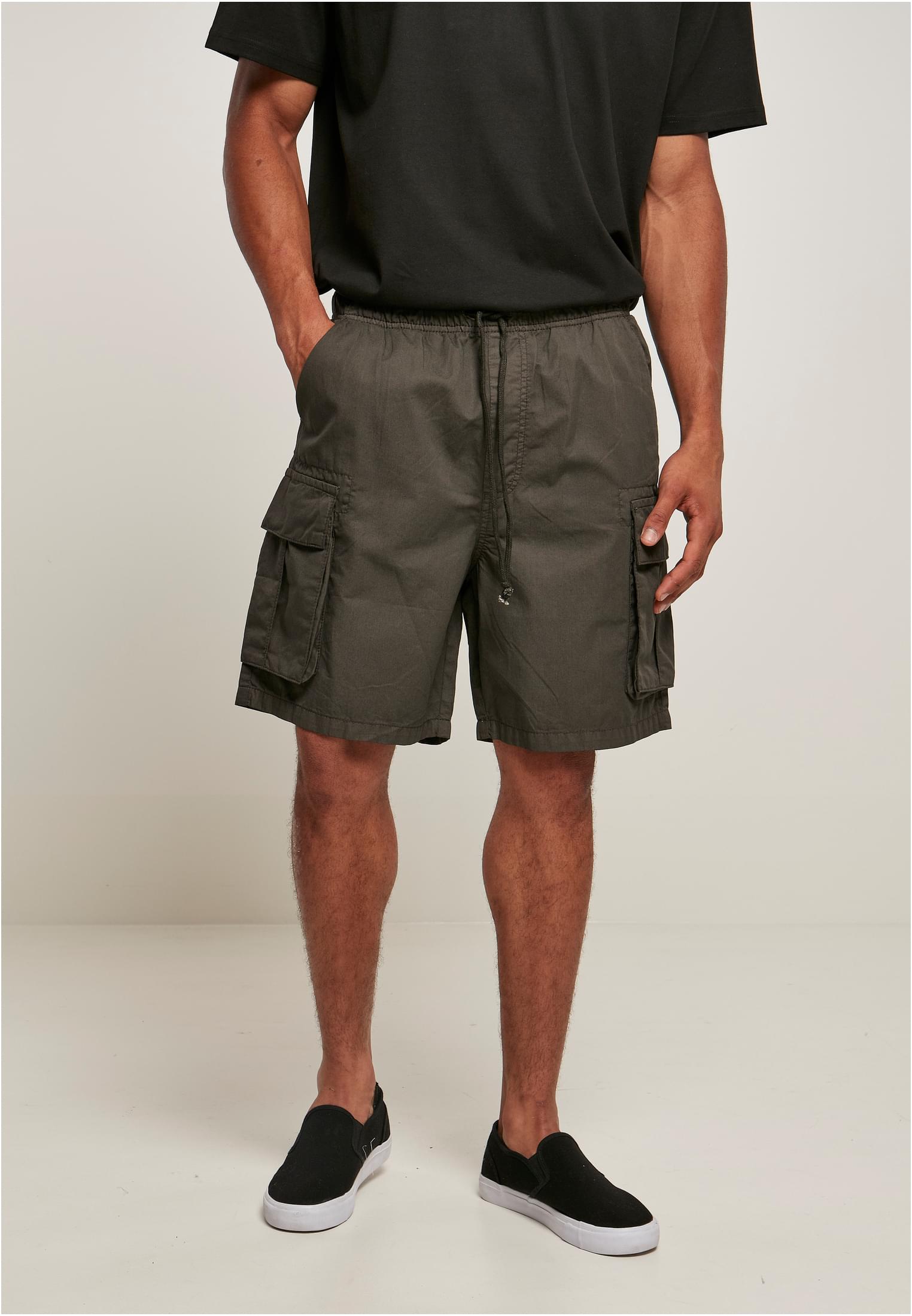 Men's short cargo shorts in cotton twill with six pockets, elastic waistband, and sporty design.