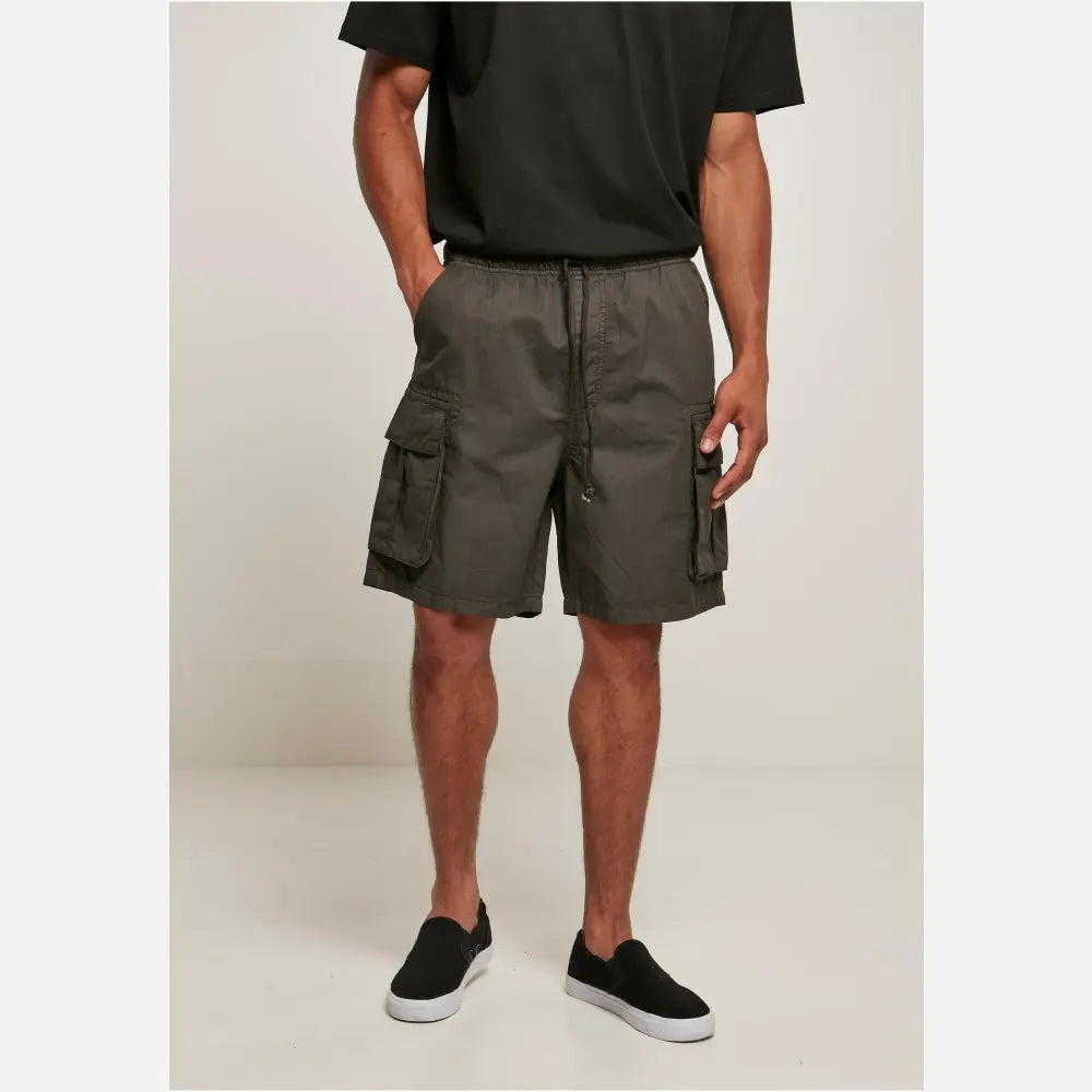 Men's short cargo shorts in cotton twill with six pockets, elastic waistband, and sporty design.