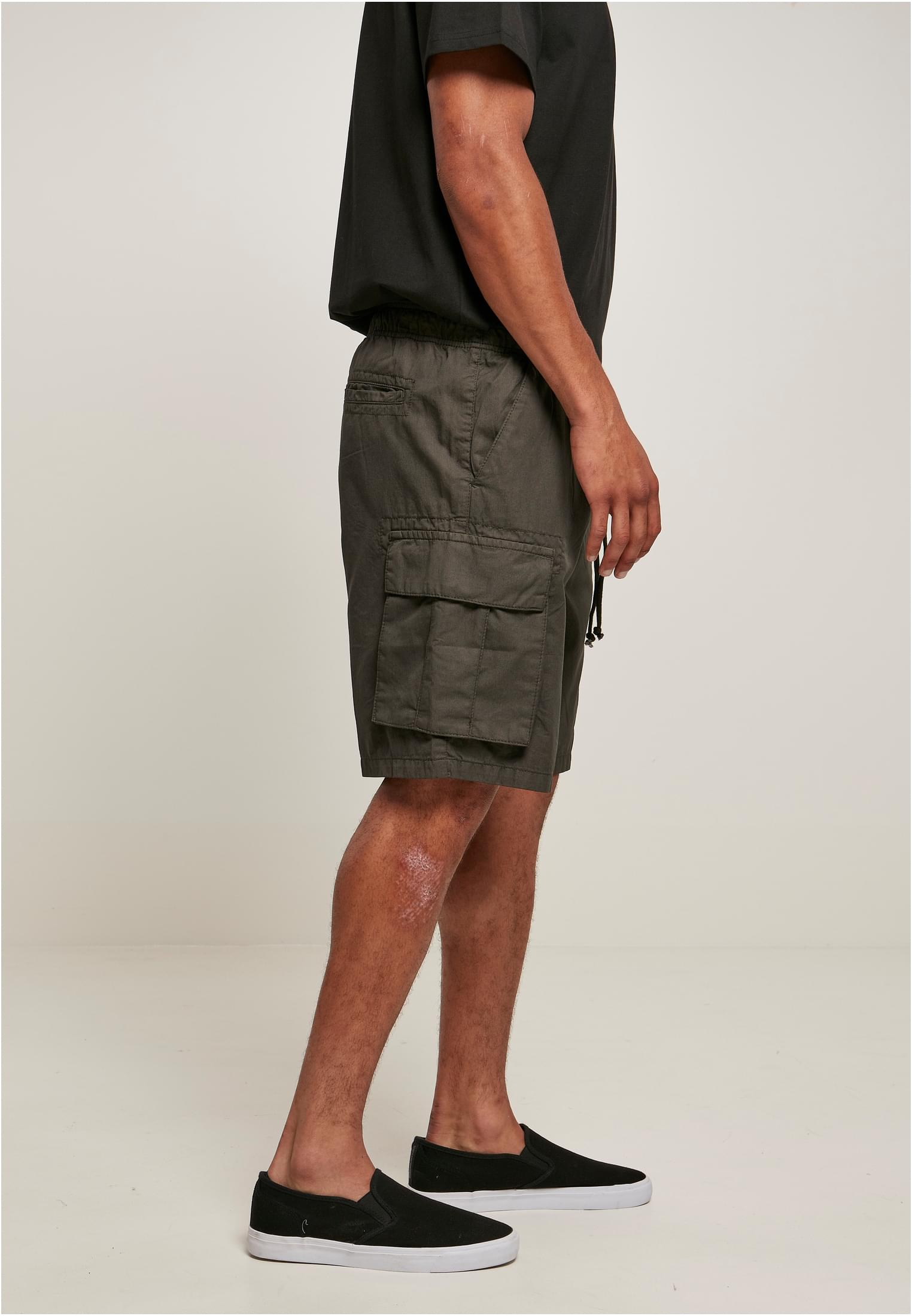Men's short cargo shorts in cotton twill with six pockets, elastic waistband, and sporty design.