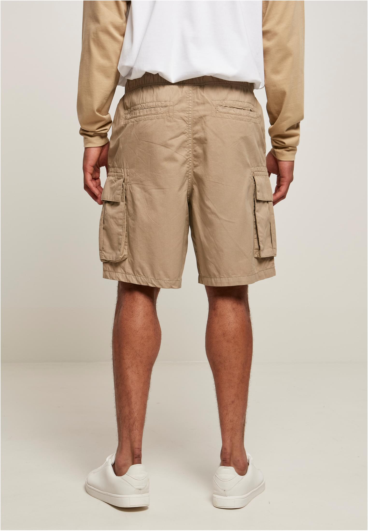 Men's short cargo shorts in cotton twill with six pockets, elastic waistband, and sporty design.