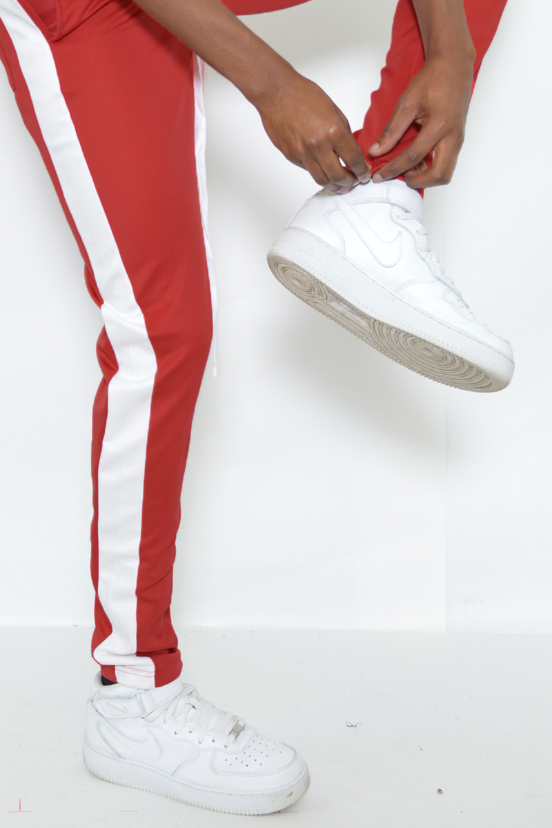 A pair of sleek slim fit track pants featuring a single stripe detail and hidden ankle zippers, perfect for athletic and casual wear.