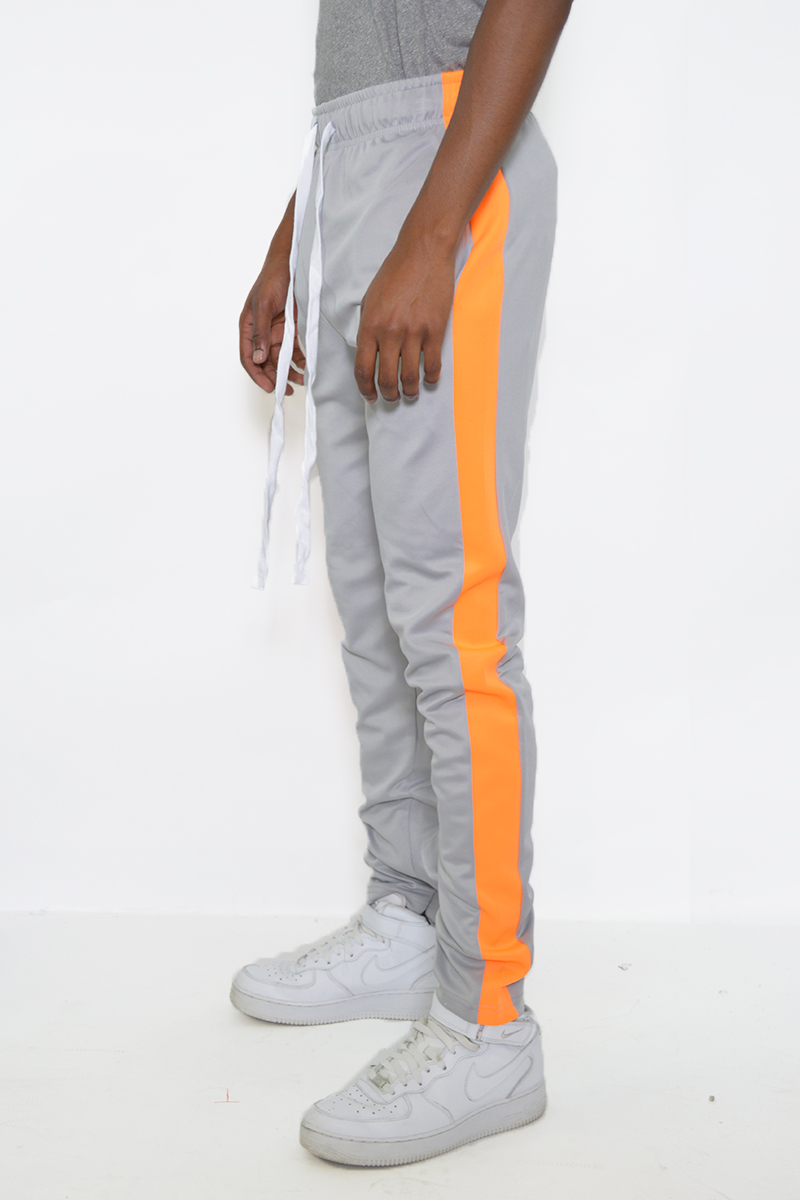 A pair of stylish slim fit track pants featuring a single stripe detail and hidden ankle zippers, perfect for workouts and casual wear.