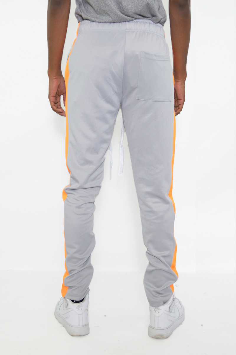 A pair of stylish slim fit track pants featuring a single stripe detail and hidden ankle zippers, perfect for workouts and casual wear.
