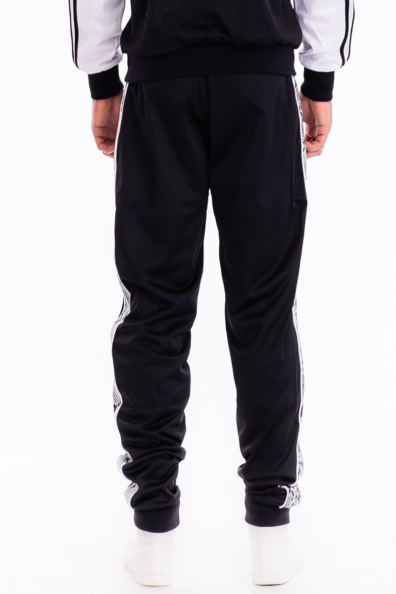 A pair of stylish SNAKE SIDE TRACK PANTS featuring an elastic waist, ankle zippers, and zippered back pockets, perfect for casual and active wear.