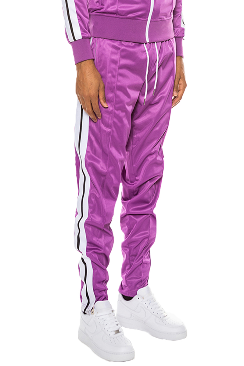 A pair of stylish striped tape track pants made from 100% polyester, featuring an elastic waist, drawstring, ankle zippers, and multiple pockets.