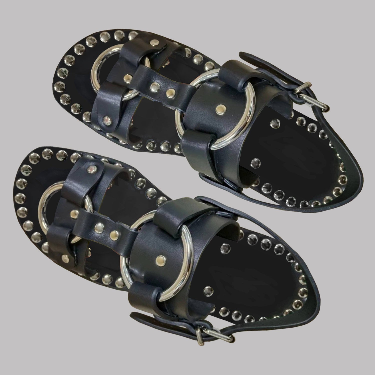 A pair of unisex hand made riveted leather sandals featuring calf leather upper and custom espadrille soles with hemp rope embellishments.