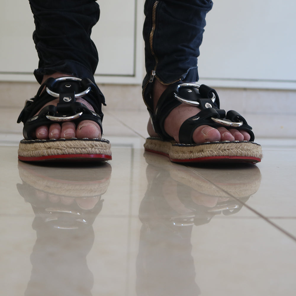 A pair of unisex hand made riveted leather sandals featuring calf leather upper and custom espadrille soles with hemp rope embellishments.