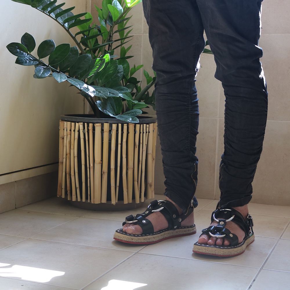 A pair of unisex hand made riveted leather sandals featuring calf leather upper and custom espadrille soles with hemp rope embellishments.