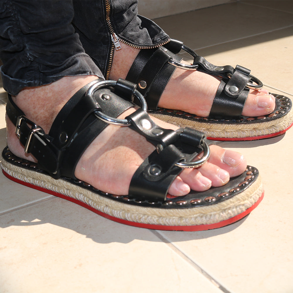 A pair of unisex hand made riveted leather sandals featuring calf leather upper and custom espadrille soles with hemp rope embellishments.