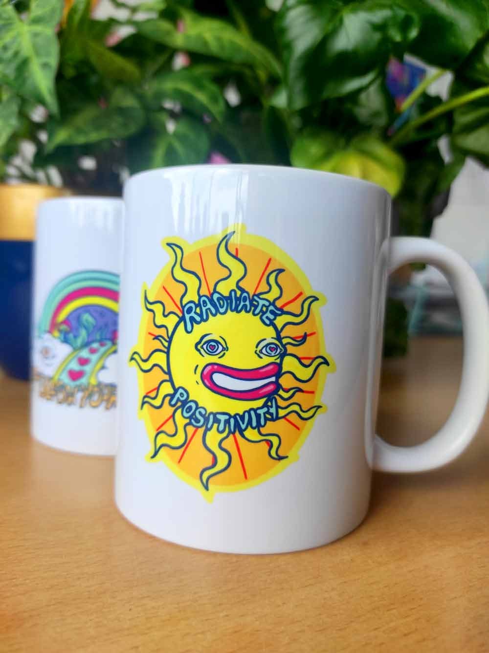 Ceramic mug featuring the design 'Radiate Positivity', showcasing vibrant colors and a cheerful message, perfect for coffee and tea lovers.