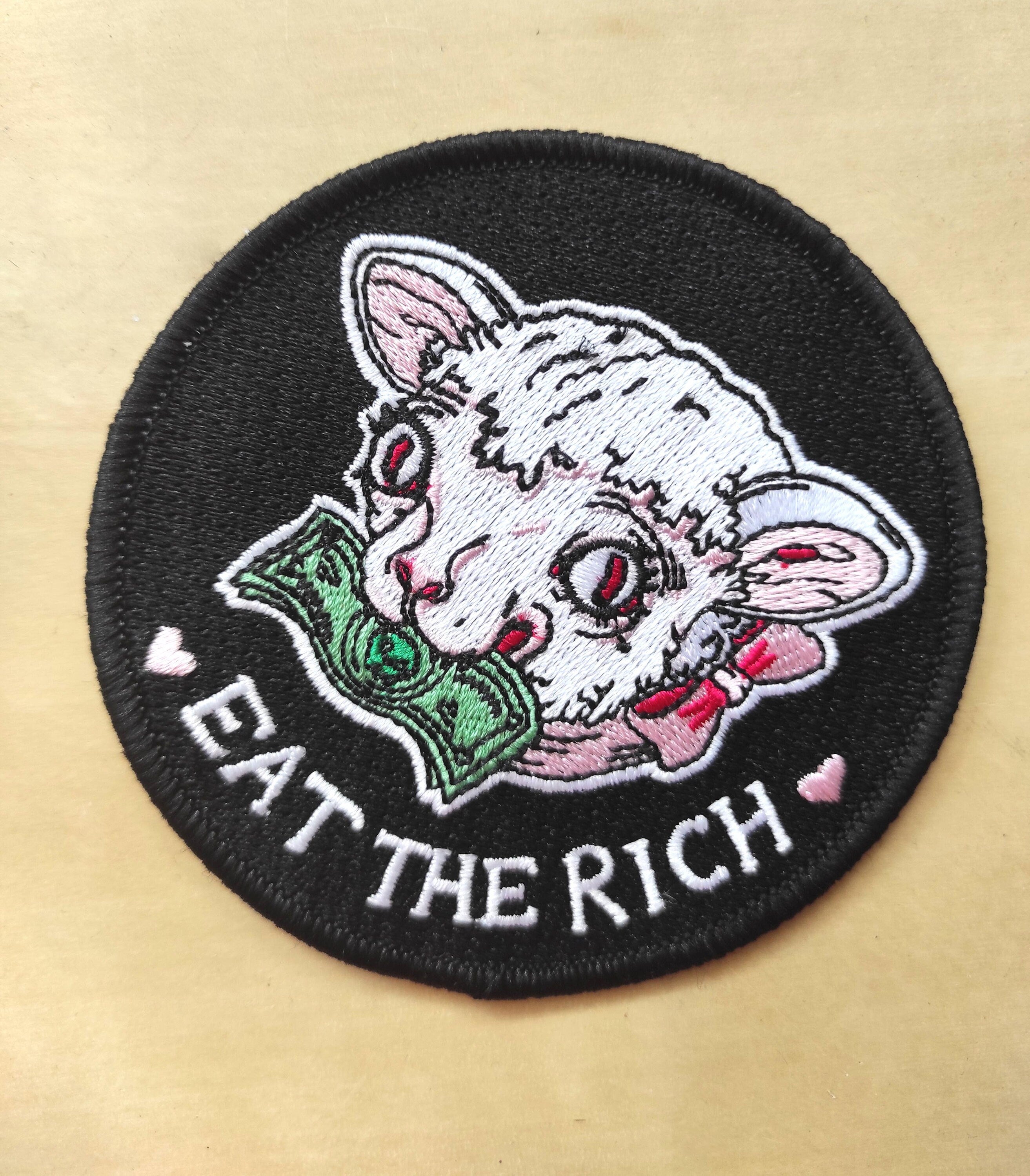 Eat the Rich Embroidered Patch featuring a Rousseau-inspired design in six vibrant colors, measuring 10cm x 10cm.