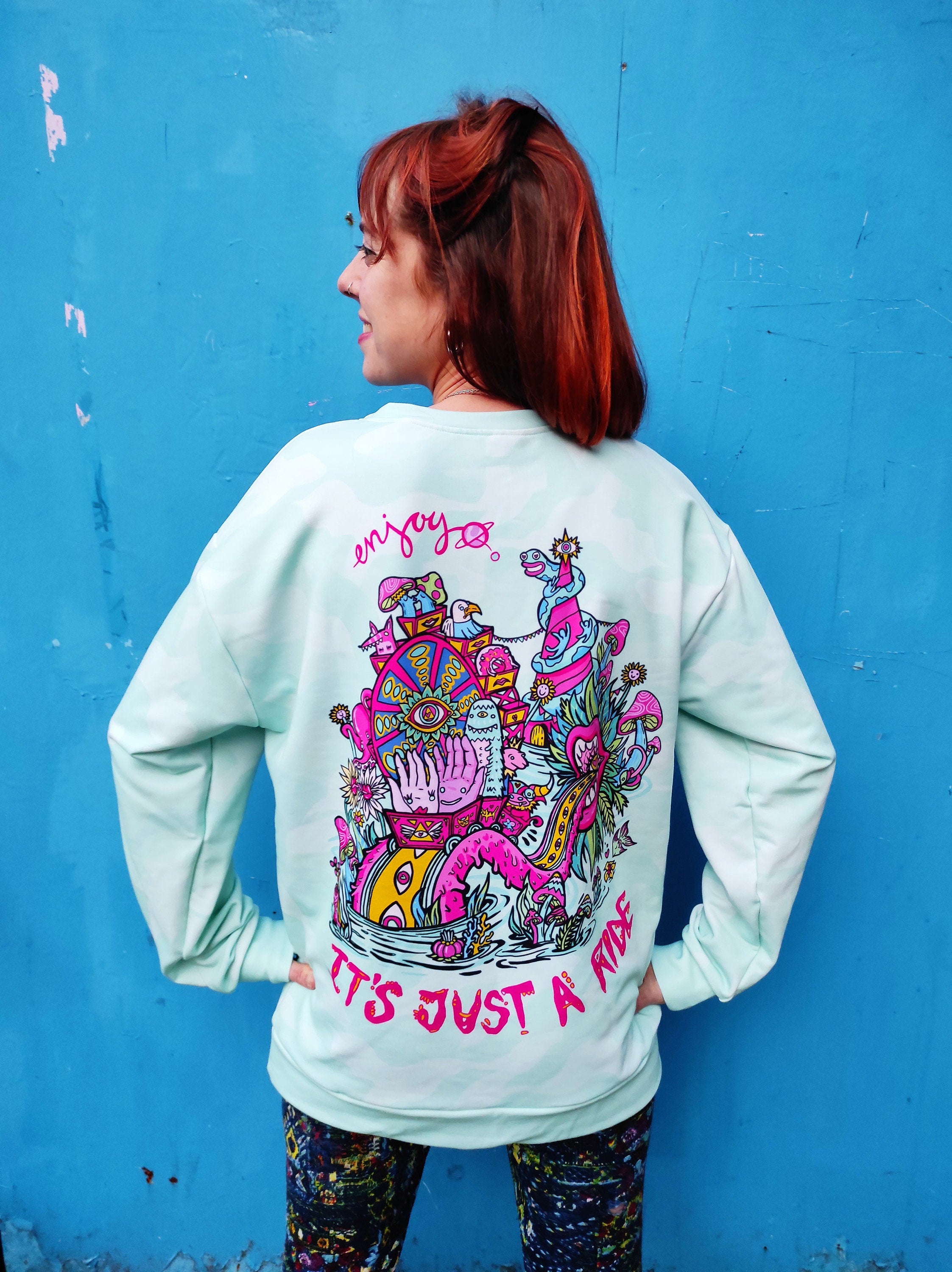 A vibrant sweatshirt featuring a psychedelic design inspired by Bill Hicks' quote about life, showcasing its soft brushed fleece interior.