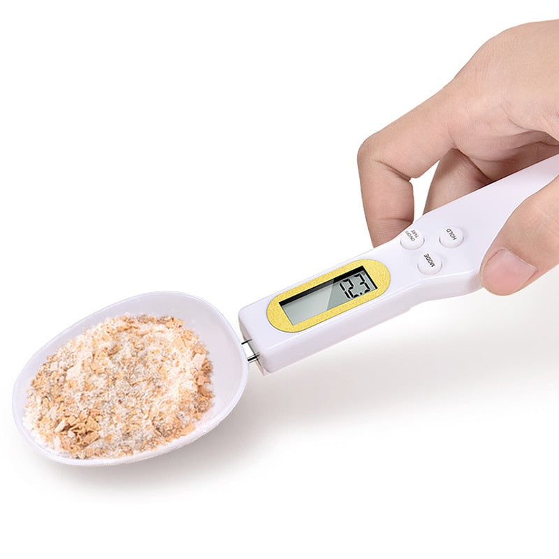 A digital kitchen measuring spoon with an LCD display, showcasing its sleek design and detachable scoop for easy cleaning.