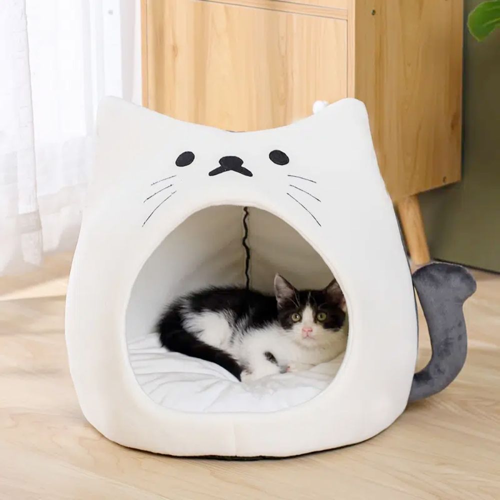 Adorable cat-shaped pet house with soft padded bed, perfect for small pets.