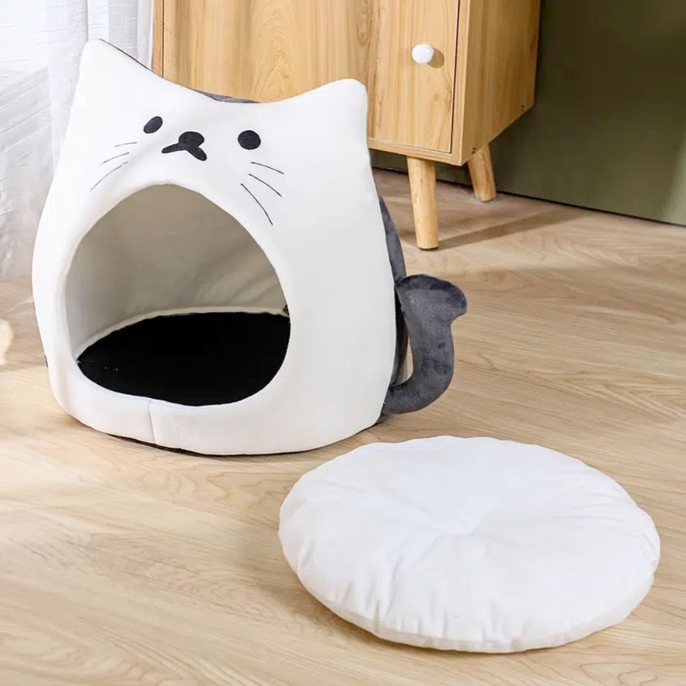 Adorable cat-shaped pet house with soft padded bed, perfect for small pets.