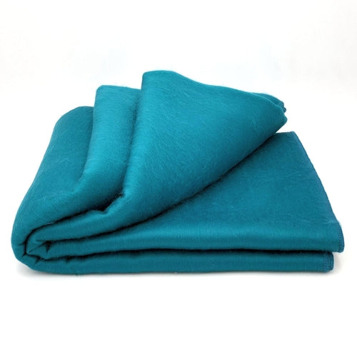 Luxurious alpaca bed blanket in various colors, showcasing its soft texture and oversized design, perfect for cozy nights.