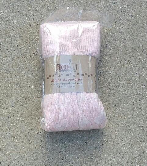 A pair of stylish thick cabled alpaca leg warmers in a cozy setting, showcasing their soft texture and fashionable design.