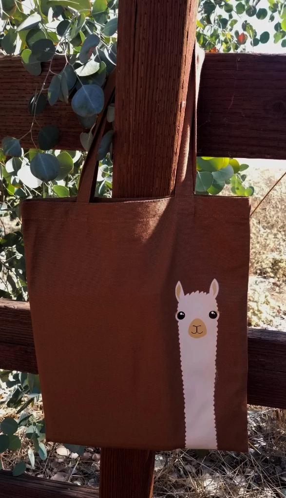A cute cotton canvas tote bag featuring an adorable alpaca design, perfect for kids and animal lovers.