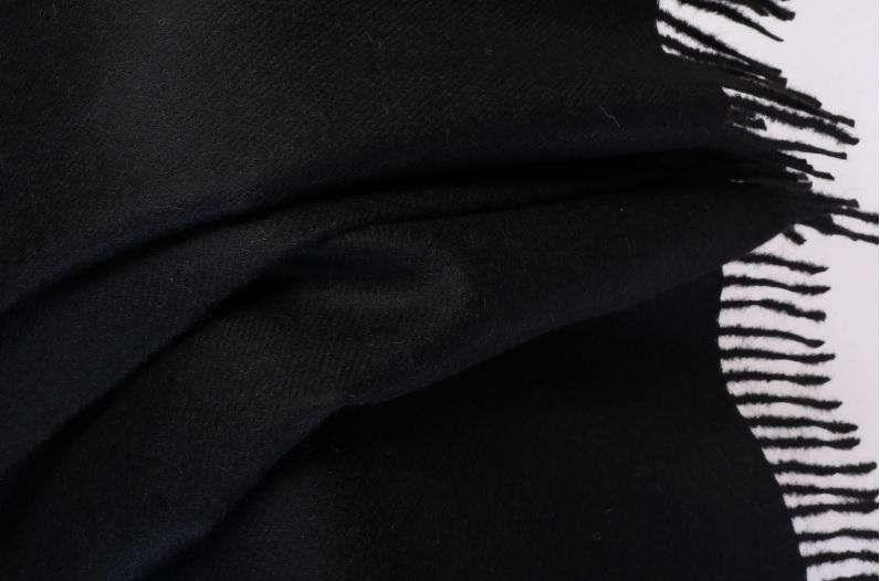 Luxurious black plaid made from 100% alpaca wool, showcasing its soft texture and elegant design.