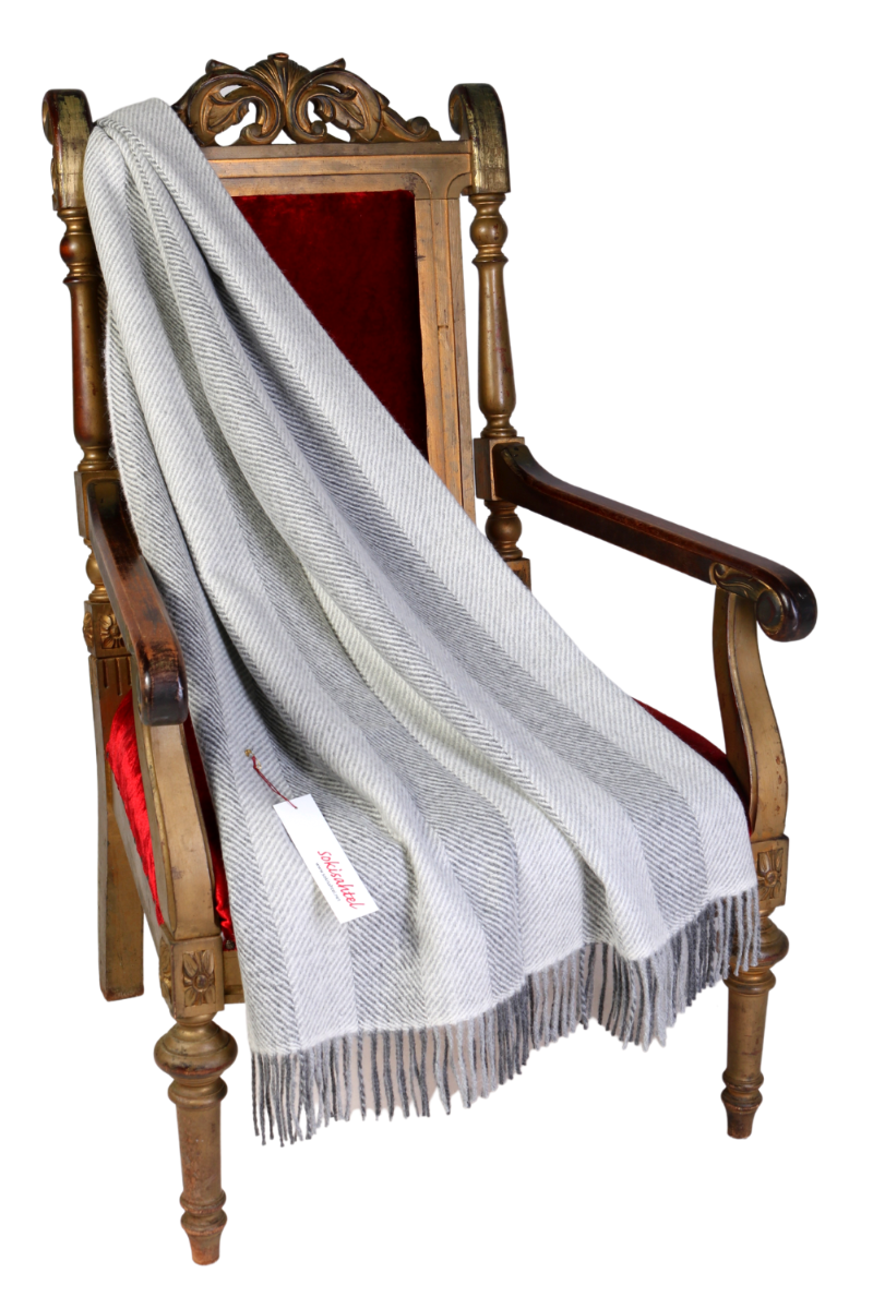 Luxurious greyish plaid blanket made from 100% alpaca wool featuring a herringbone pattern, perfect for cozy winter days.