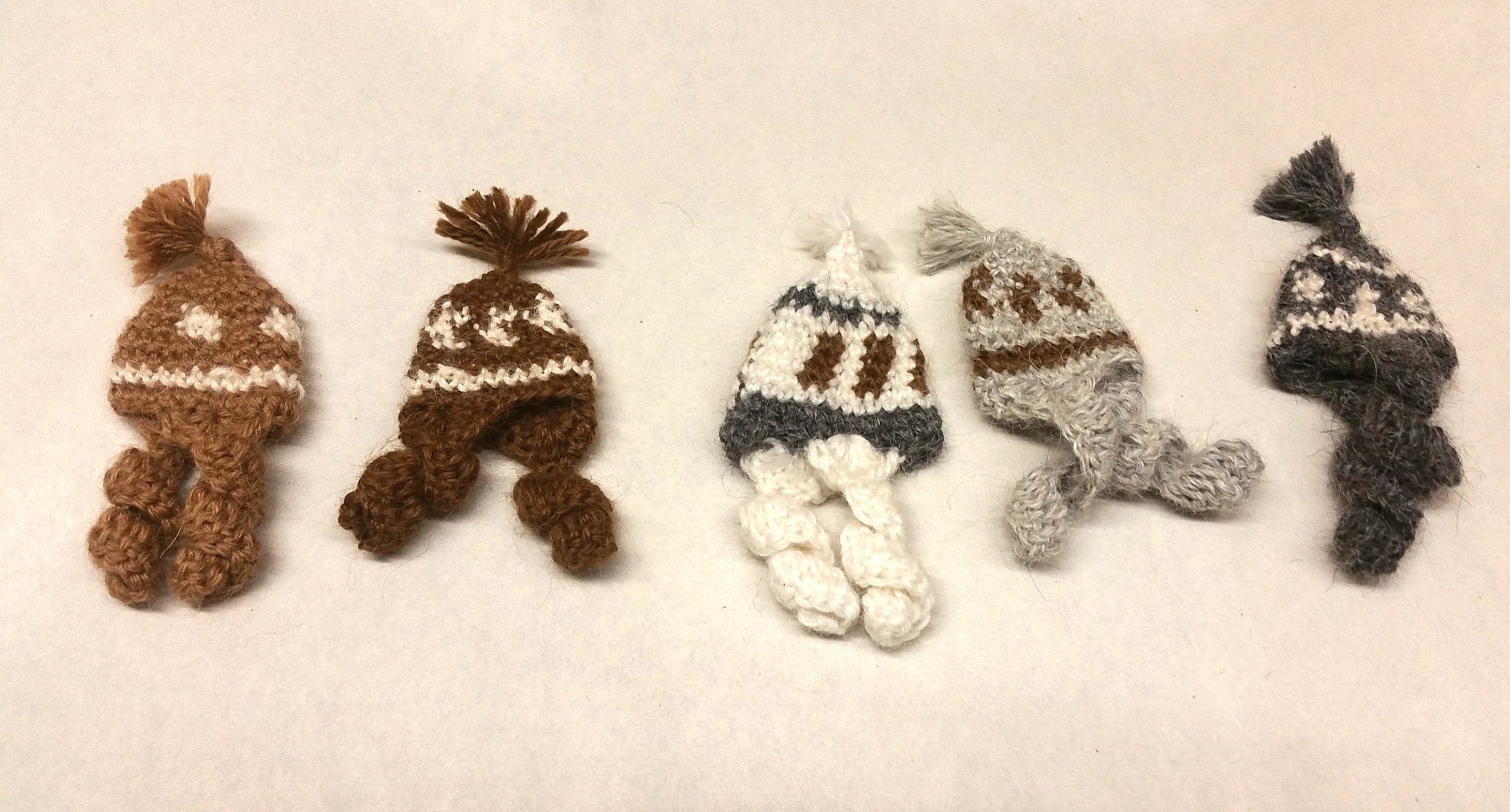 A collection of adorable hand made baby alpaca ornaments in various colors and sizes, showcasing their unique craftsmanship and charm.