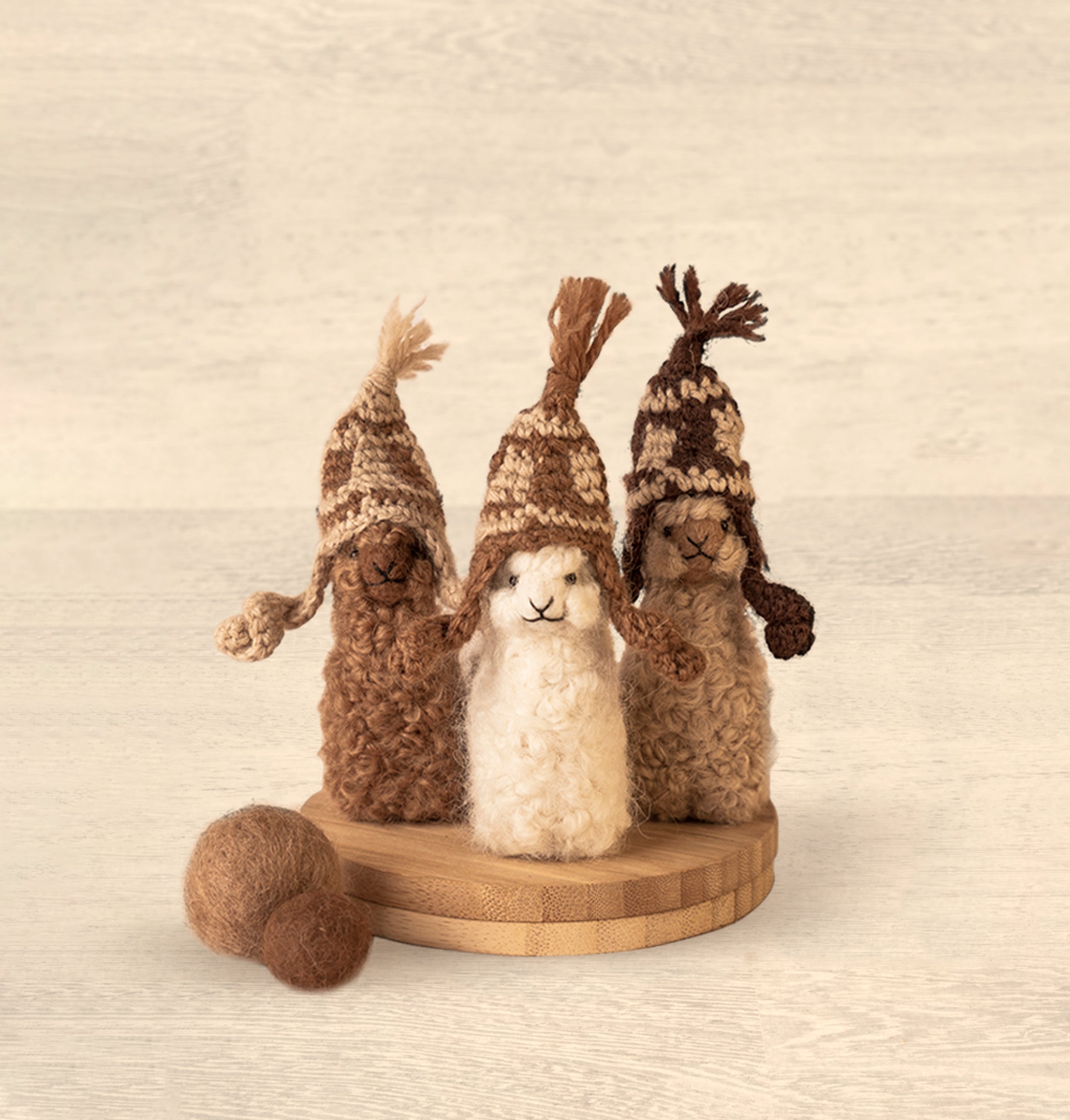A collection of adorable hand made baby alpaca ornaments in various colors and sizes, showcasing their unique craftsmanship and charm.