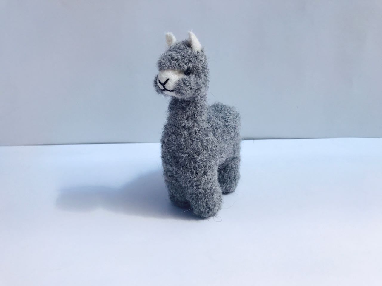 A collection of adorable hand made baby alpaca ornaments, showcasing their unique designs and soft textures, perfect for holiday decorations.