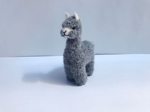 A collection of adorable hand made baby alpaca ornaments, showcasing their unique designs and soft textures, perfect for holiday decorations.