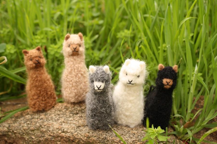 A collection of adorable hand made baby alpaca ornaments, showcasing their unique designs and soft textures, perfect for holiday decorations.