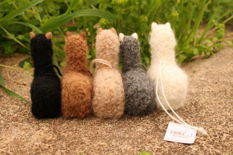 A collection of adorable hand made baby alpaca ornaments, showcasing their unique designs and soft textures, perfect for holiday decorations.