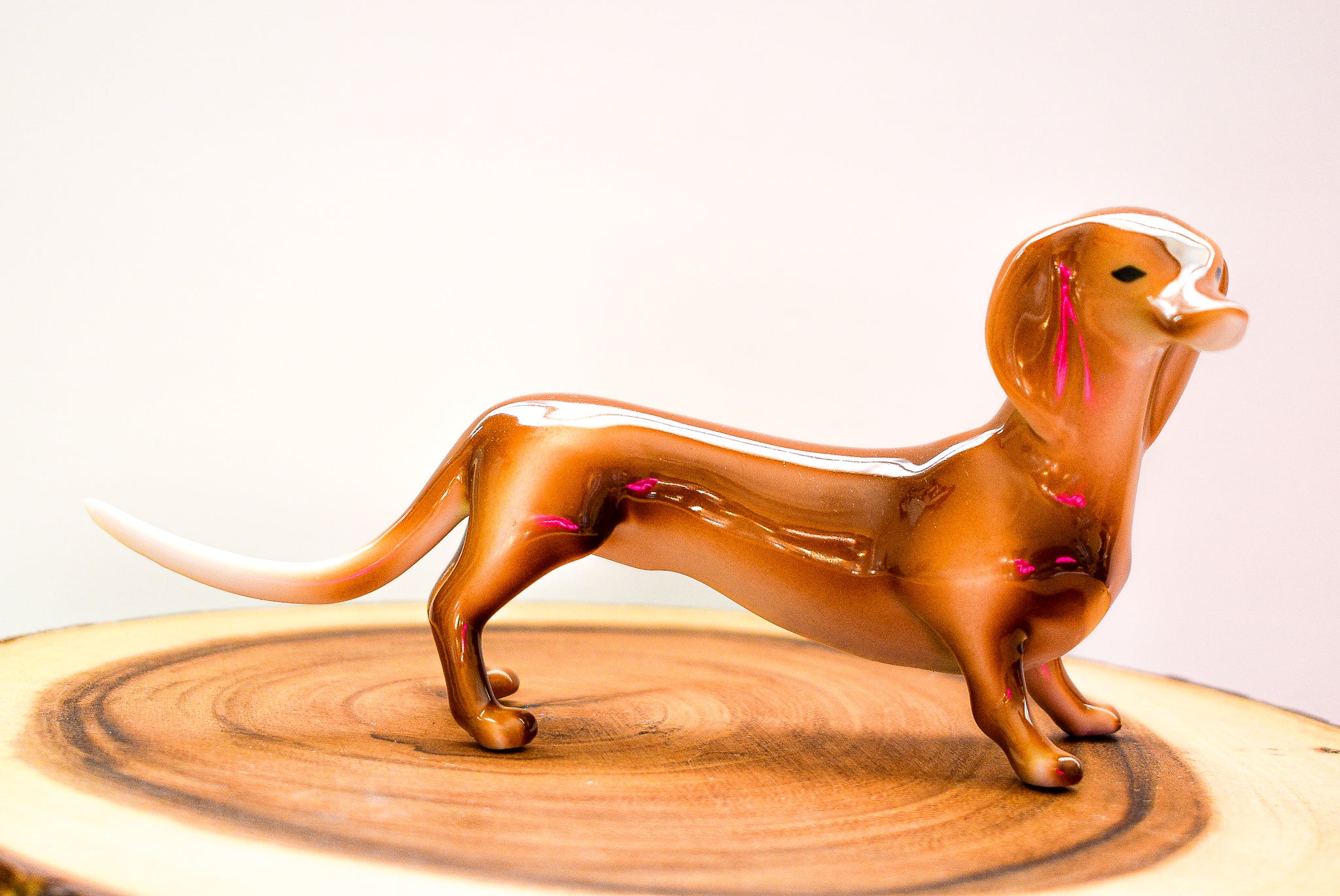 Art-Deco Dachshund Figurine in a basket, made of resin, showcasing intricate details and vibrant colors.