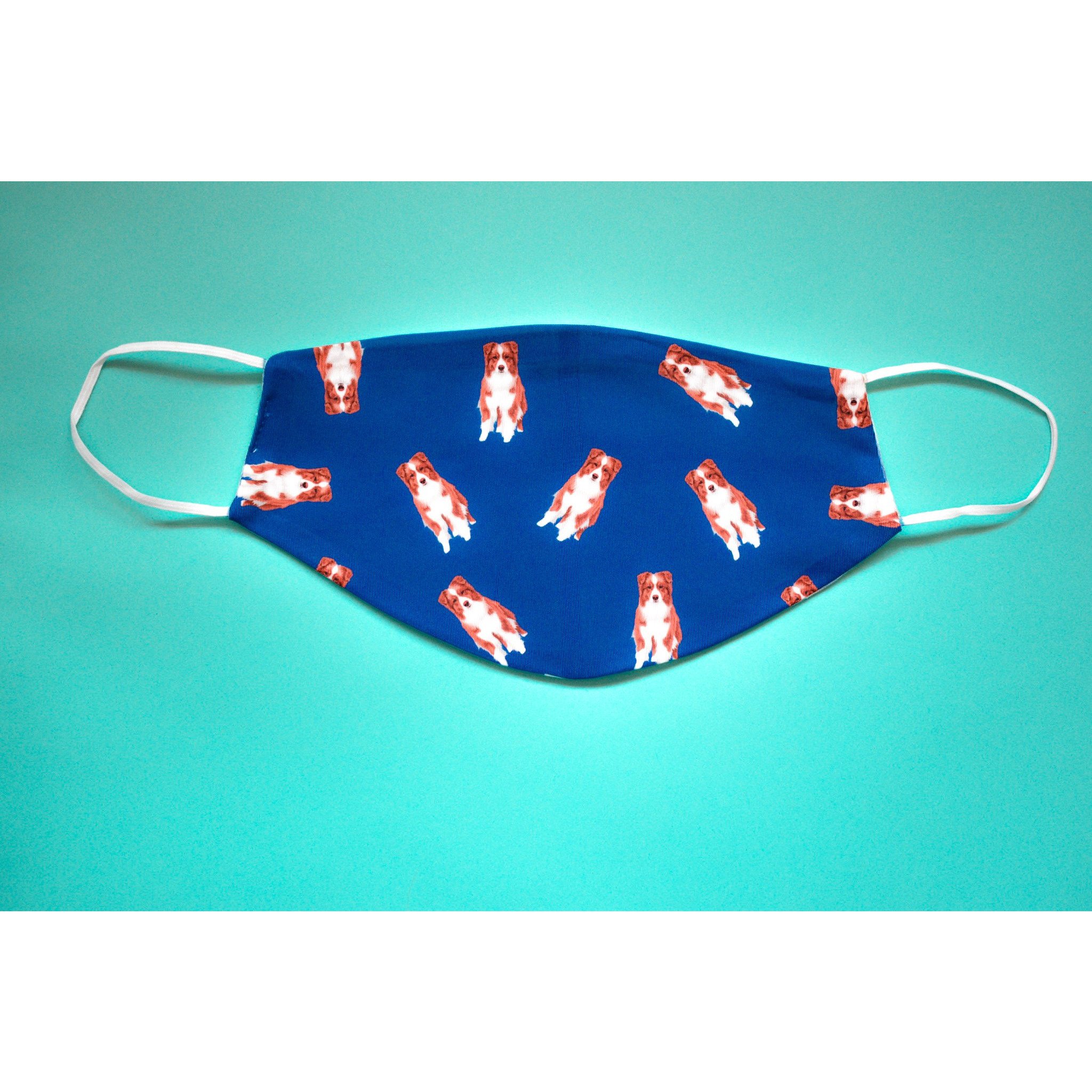 A handmade Australian Shepherd face cover featuring a colorful design, made from breathable polyester and soft organic cotton, suitable for everyday use.