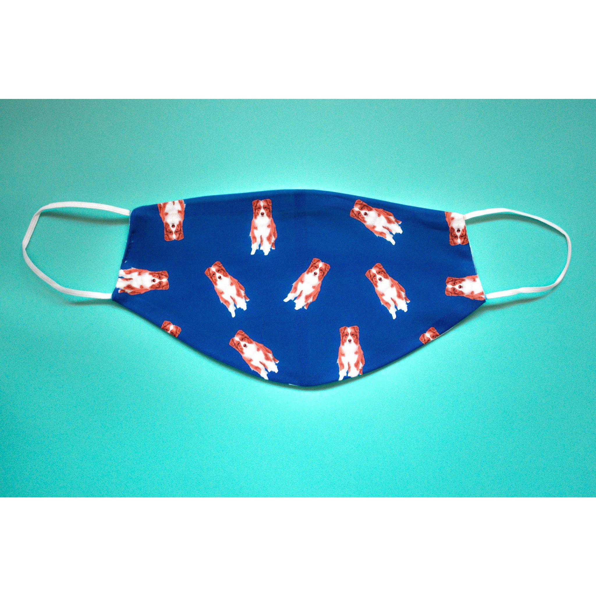 A handmade Australian Shepherd face cover featuring a colorful design, made from breathable polyester and soft organic cotton, suitable for everyday use.