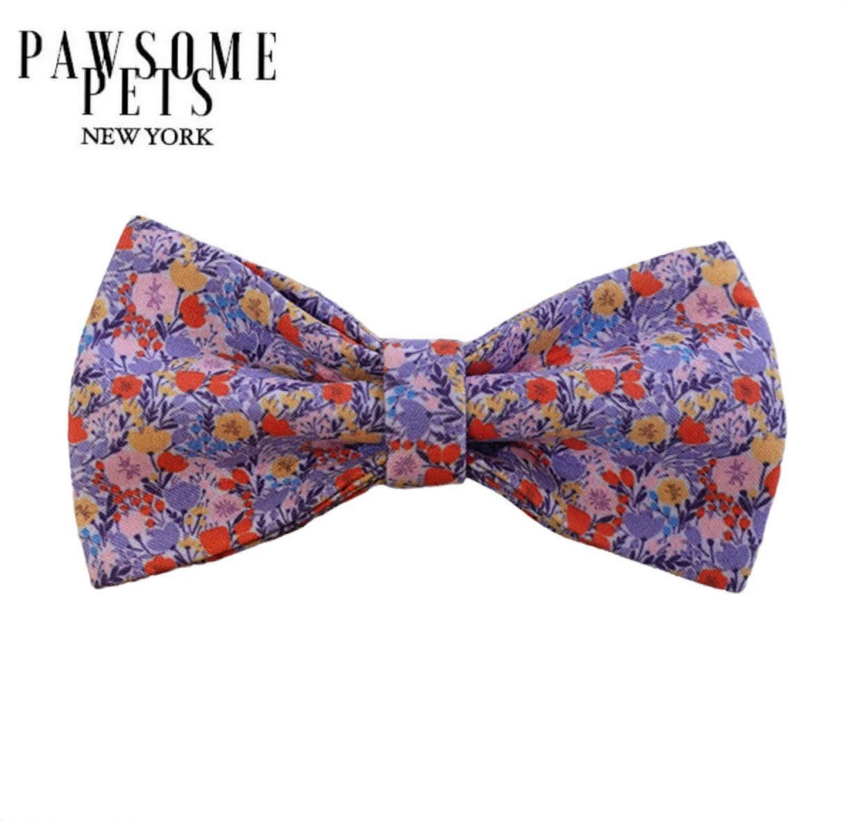 A vibrant floral bowtie designed for pets, featuring genuine Velcro straps for easy attachment and made from soft cotton material.