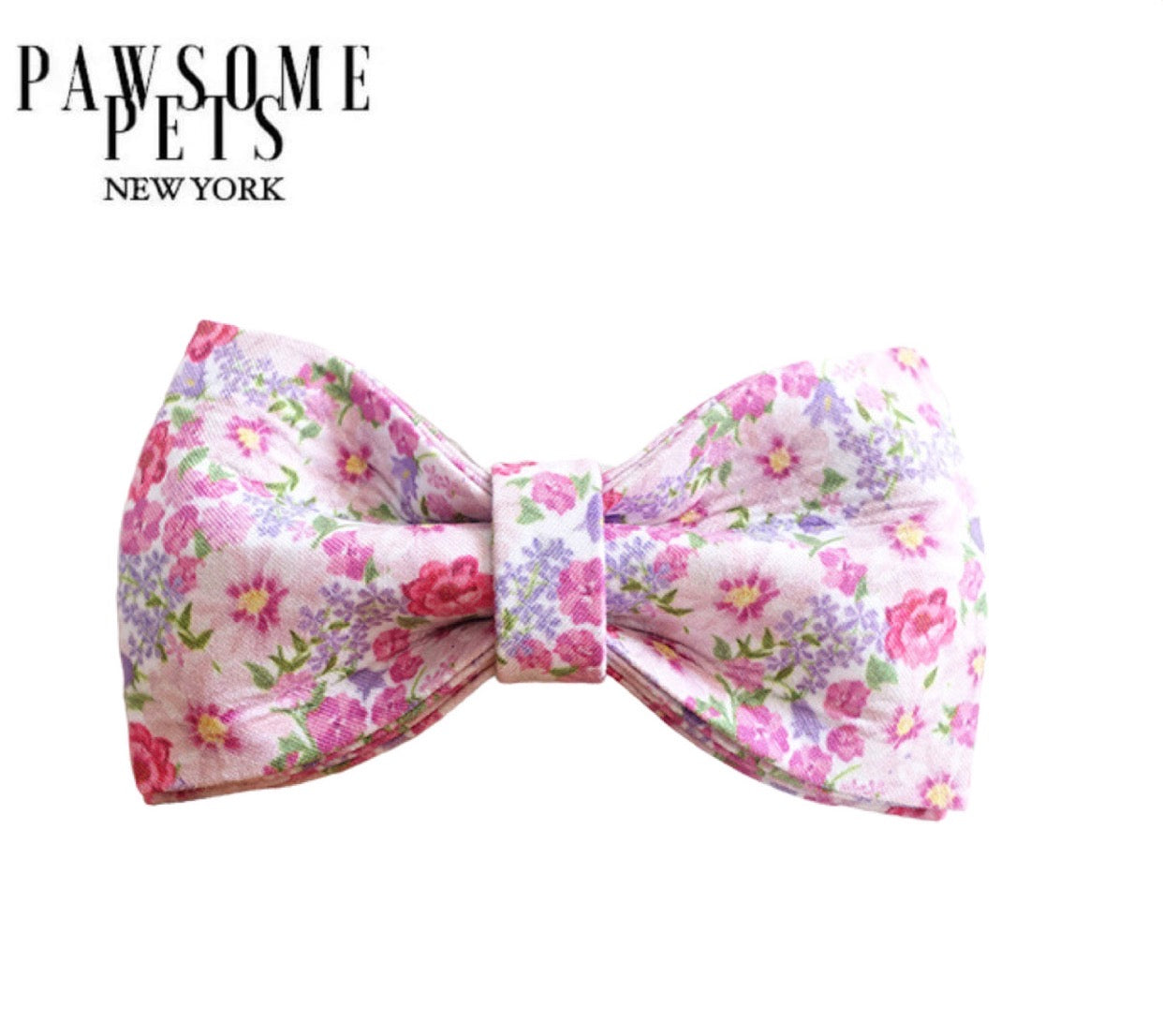 A stylish pink floral bow tie made from 100% cotton with Velcro straps for easy attachment to a pet's collar.
