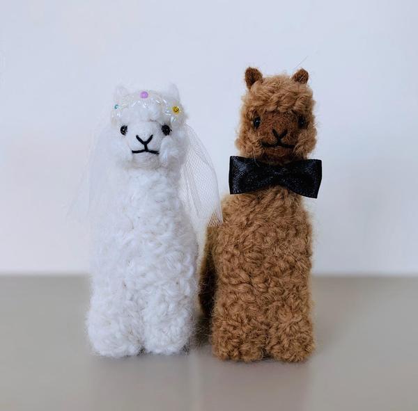 Handmade baby alpaca ornaments depicting a bride and groom, showcasing intricate details and soft textures, perfect for weddings and festive decor.
