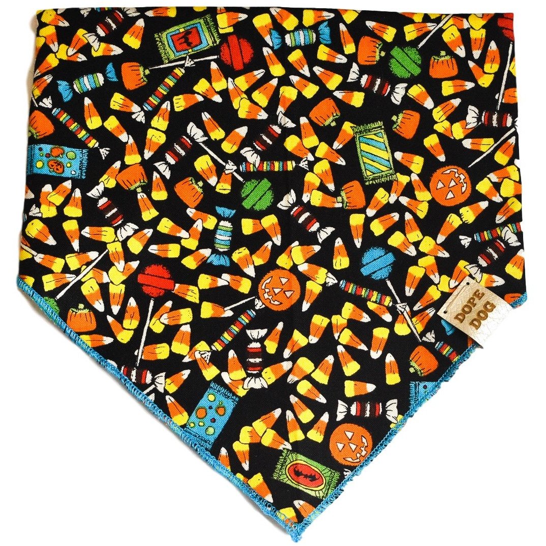 Candy Corn Cutie dog bandana featuring a vibrant candy corn pattern, handmade with cotton fabric and a vegan leather tag.