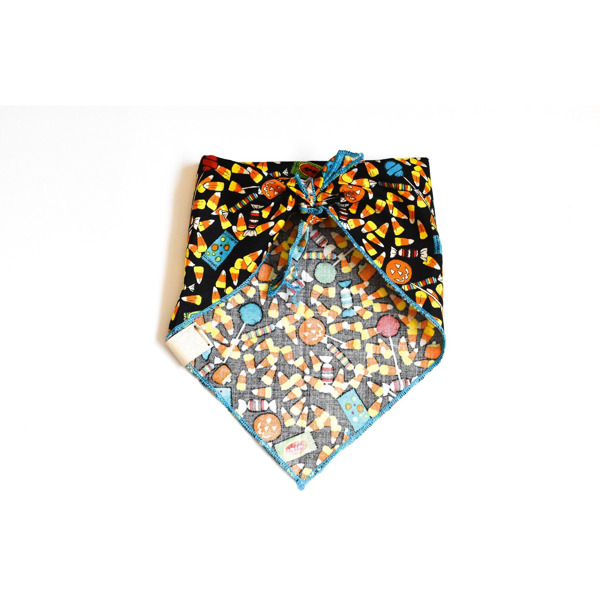 Candy Corn Cutie dog bandana featuring a vibrant candy corn pattern, handmade with cotton fabric and a vegan leather tag.