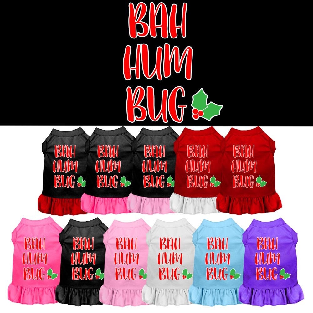 A cute dog wearing a Christmas dress with 'Bah Humbug' printed on it, showcasing a festive yet humorous design.