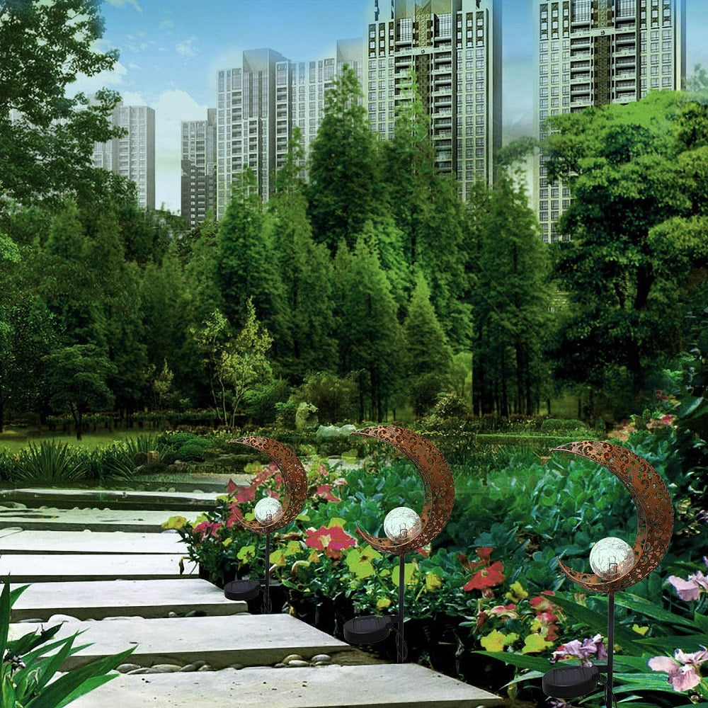 Crackle Glass Globe Metal Light illuminating a garden path, showcasing its beautiful design and warm white LED glow.