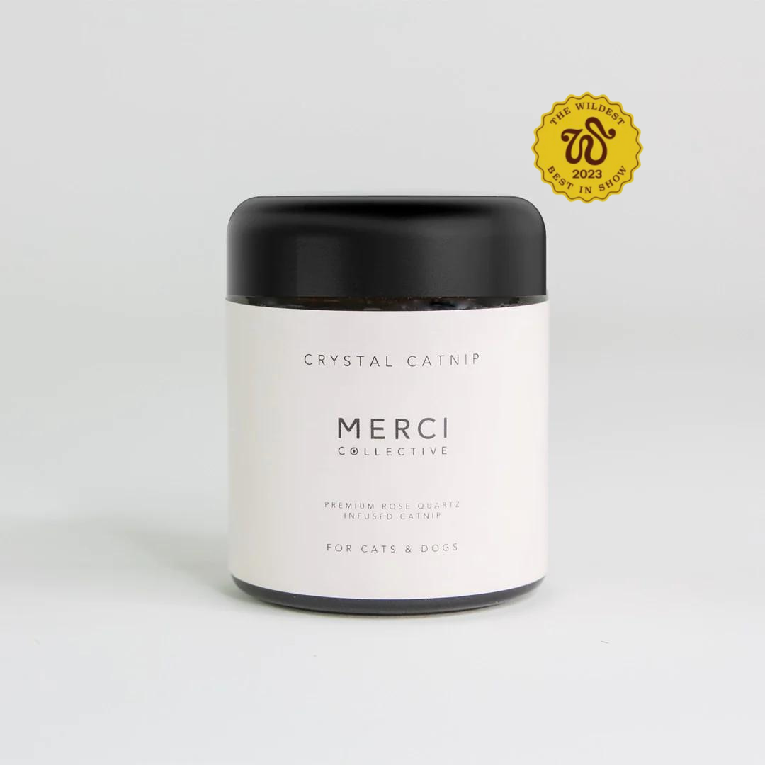 A bag of premium Rose Quartz crystal-infused catnip, finely ground for easy use, with a soft pink hue and sparkling crystals visible.