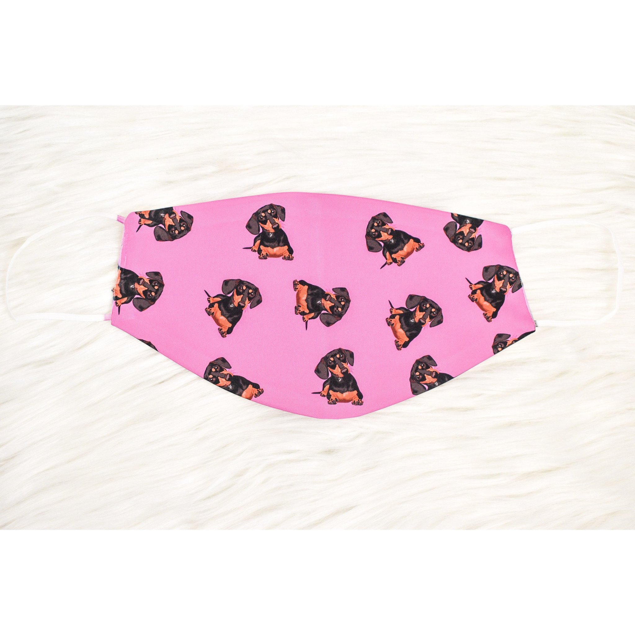 A stylish black and tan dachshund face cover, handmade with breathable fabric, showcasing a cute dog print.